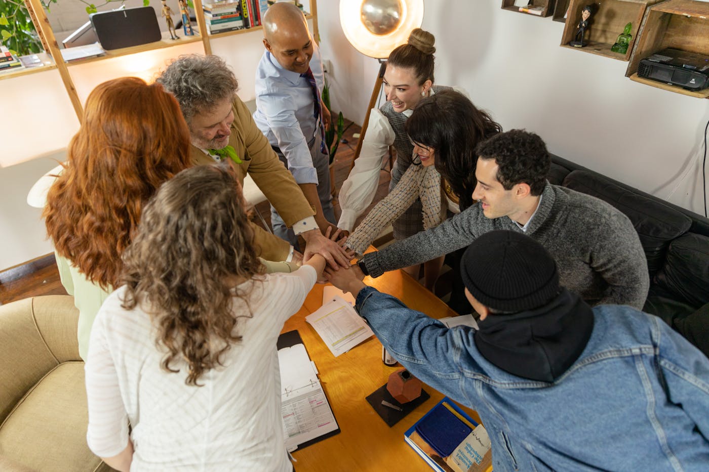 People placing hands together during a meeting