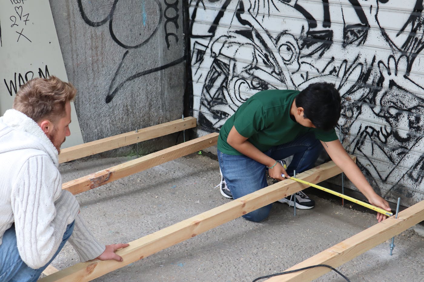 Two people working together on a timber structure